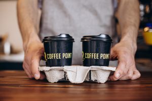 maennlicher-barista-serviert-kaffee-in-pappbechern_1303-31766