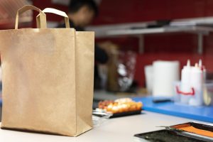 man-preparing-sushi-order-takeaway_23-2149050378