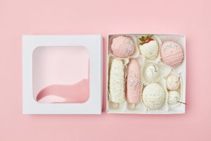 offene-geschenkbox-mit-fruechten-in-weisser-und-rosa-schokolade_120225-5